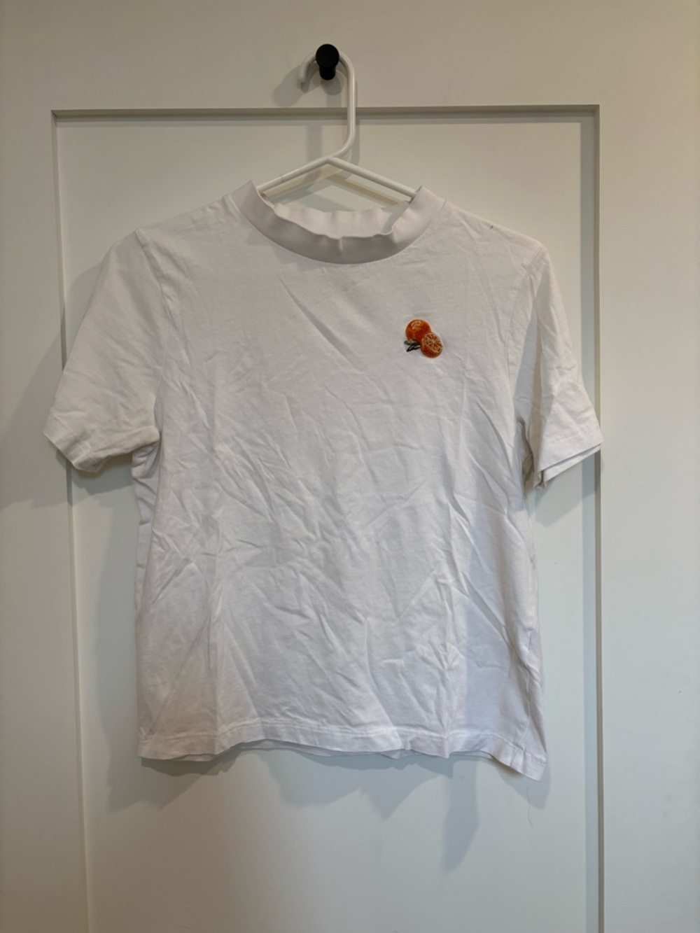100% organic cotton Simons White Crewneck Tee with orange embroidery